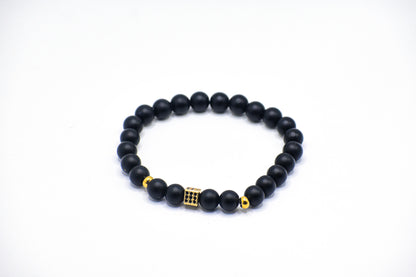 Black onyx healing bracelet with gold spacer and paved gold black onyx, cubed charm ￼